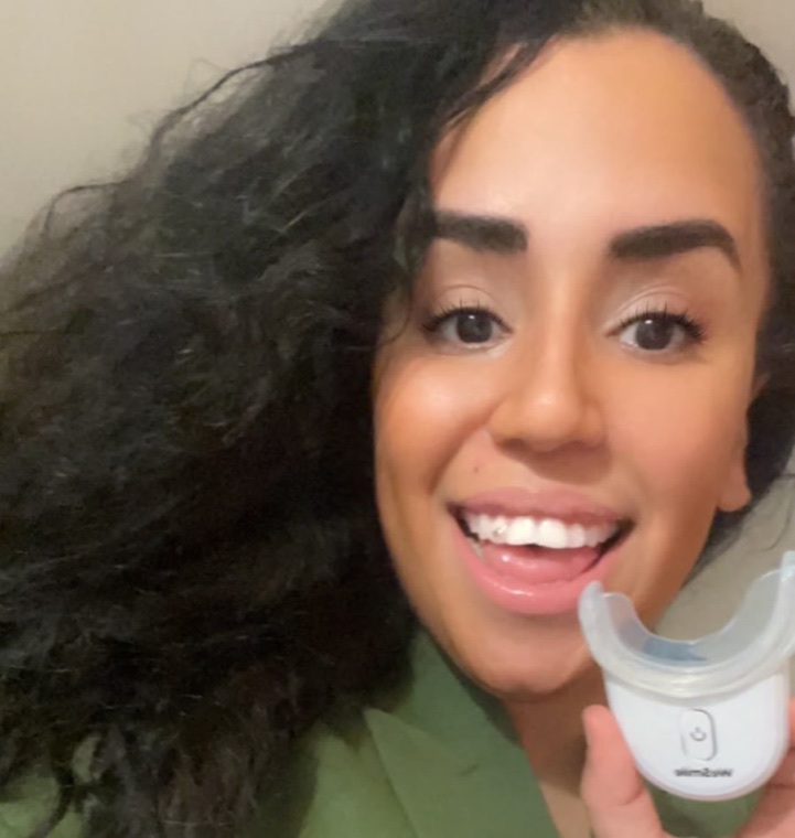 Mohiba Talhaoui lächelt und hält die WeSmile LED-Schiene hoch
